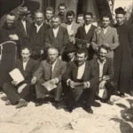 Uomini del coro parrocchiale in posa con i loro spartiti in mano.